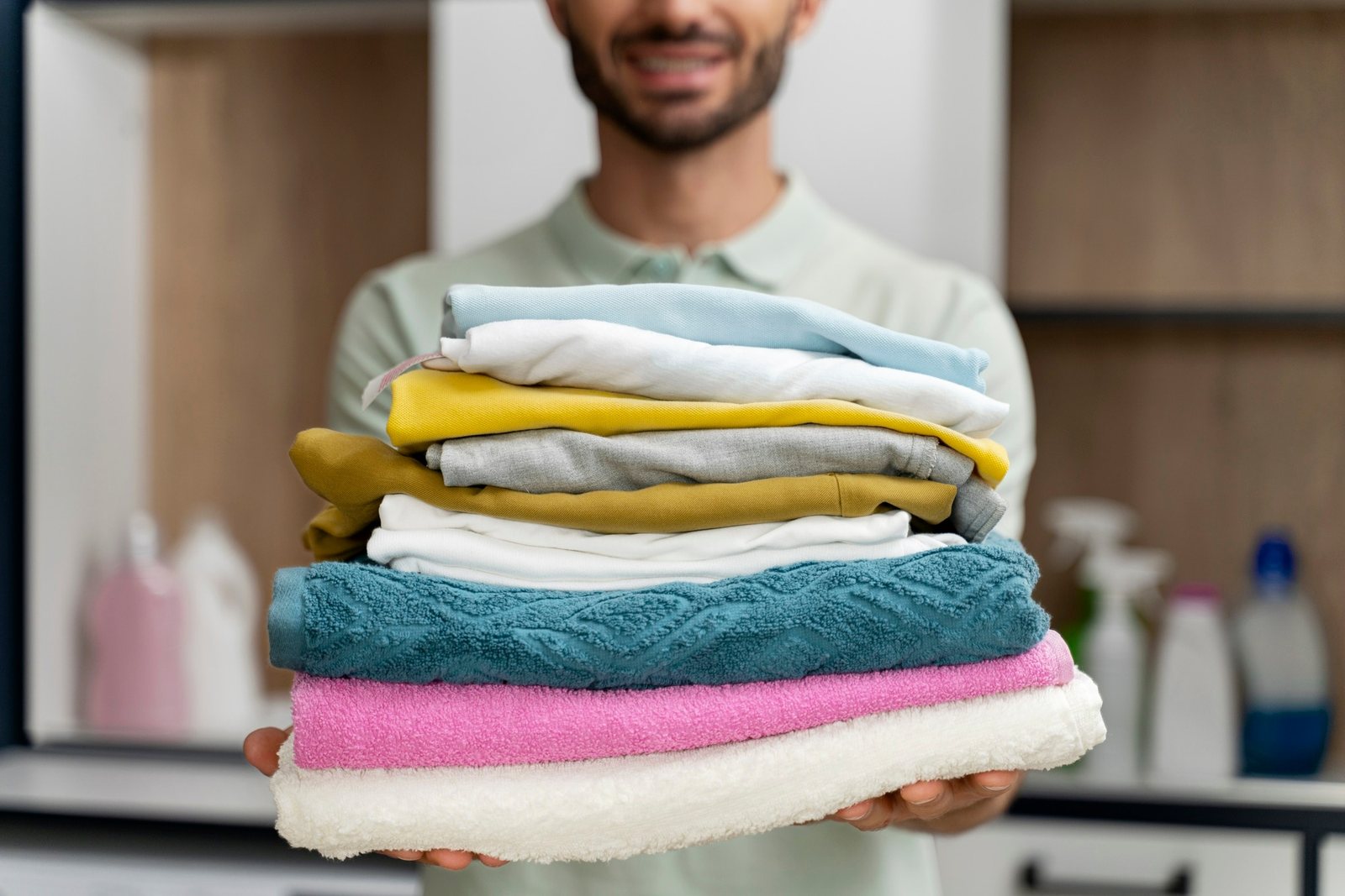 man holding clean clothes after laundry